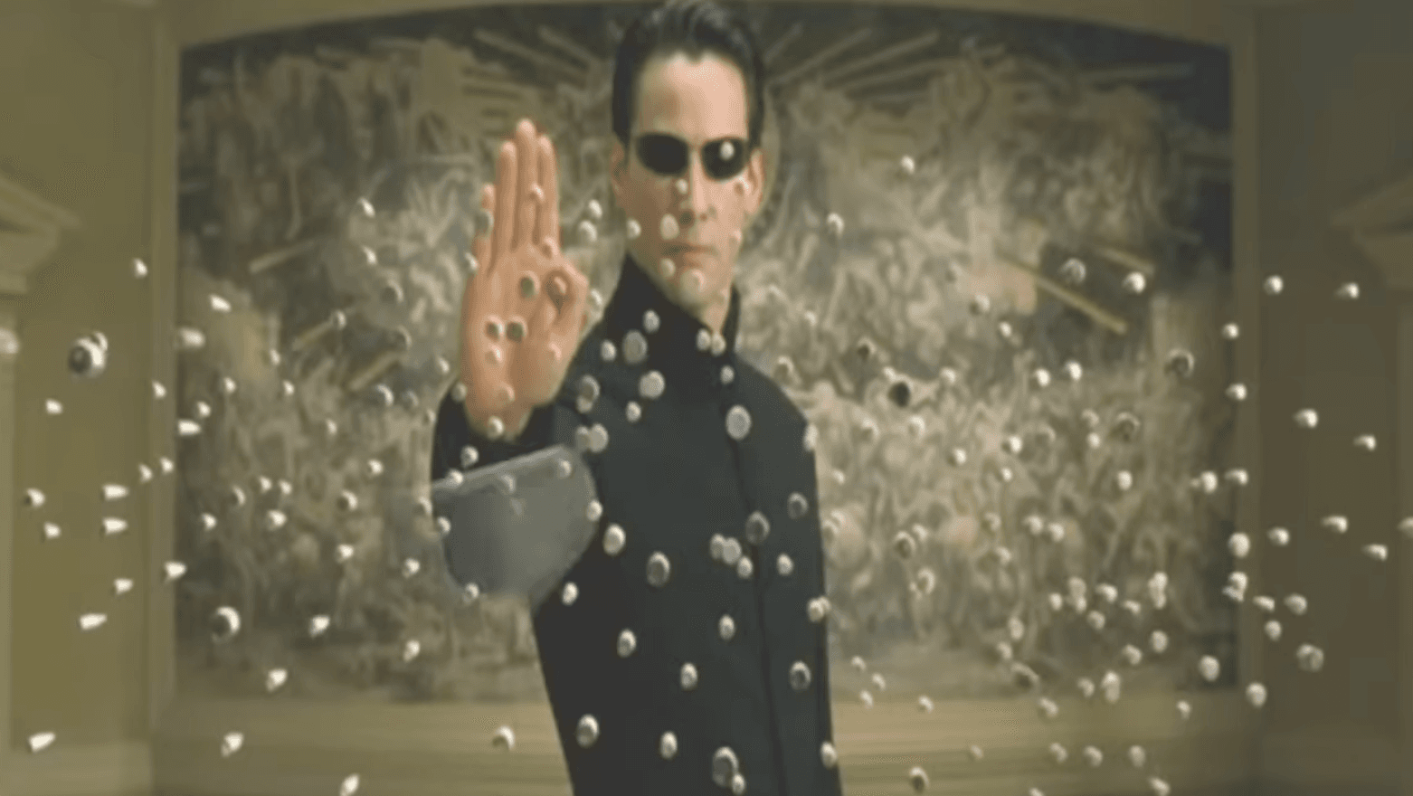 Neo, personaggio del film Matrix, ferma un gran numero di proiettili.